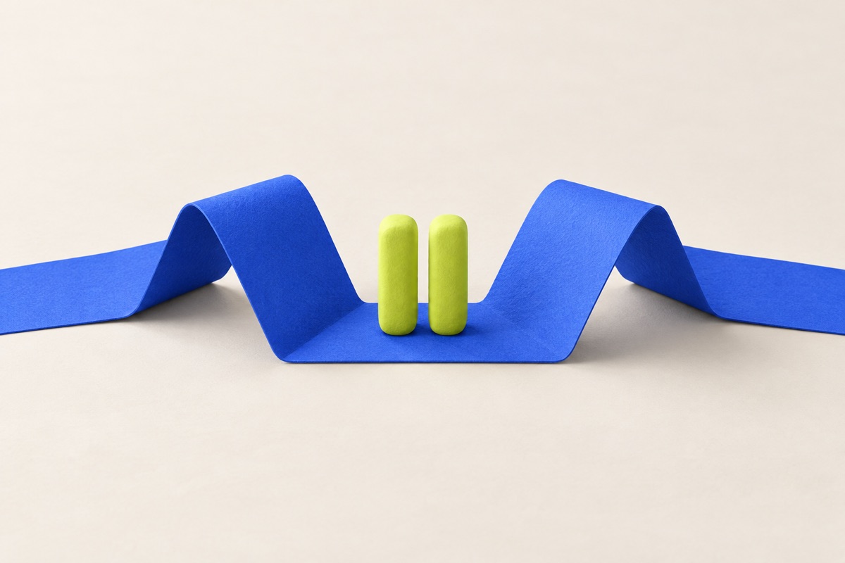 Two lime-green pause bars sit in the fold of a continuous blue paper ribbon, illustrating a pause rather than an erased career.