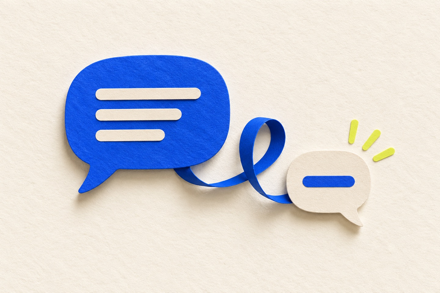 A blue paper message bubble connects by a looping ribbon to a small cream reply bubble.